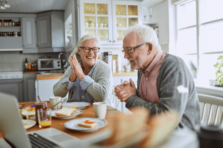 man and woman sat laughing in the kitchen with dentures